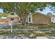 Charming home featuring stone accents, a well-manicured lawn, and mature landscaping at 5441 Justine Way, Winter Park, FL 32792