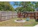 A rustic fire pit area is surrounded by a wood fence and landscaping, inviting relaxation at 5441 Justine Way, Winter Park, FL 32792