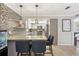 Modern kitchen featuring granite countertops, stylish backsplash, and breakfast bar seating at 5441 Justine Way, Winter Park, FL 32792
