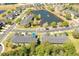 An aerial view of multi-Gathering homes in a neighborhood with a lake and mature trees at 5565 Gelato Dr, Orlando, FL 32829