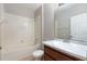 Clean bathroom with white tile, a tub/shower combination, and a wood vanity at 5565 Gelato Dr, Orlando, FL 32829