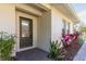 Inviting front door with glass and manicured landscaping including colorful plants at 5565 Gelato Dr, Orlando, FL 32829