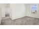 Bedroom with connecting bathroom boasts neutral decor, carpet, and a window at 640 Trotters Dr, Eagle Lake, FL 33839