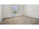 This bedroom features plush carpeting, neutral walls, and a window offering natural light at 640 Trotters Dr, Eagle Lake, FL 33839