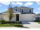 Two-story home with neutral stucco, stone accents, a two-car garage and manicured lawn at 640 Trotters Dr, Eagle Lake, FL 33839