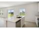 Modern kitchen features a large center island, stainless steel appliances, and a view to the back yard at 640 Trotters Dr, Eagle Lake, FL 33839