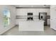 This modern kitchen boasts white cabinetry, stainless steel appliances, and a center island with a sink at 640 Trotters Dr, Eagle Lake, FL 33839