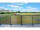 A wooden deck offers expansive view of a fenced yard under a bright, cloudy sky at 6607 Whispering Pines Rd, Orlando, FL 32824