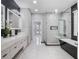 This bathroom features a double vanity, modern fixtures, beautiful tile and an open shower and black stand alone soaking tub at 6607 Whispering Pines Rd, Orlando, FL 32824