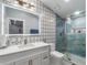 This bathroom features a single vanity with modern fixtures, colorful tile and glass shower at 6607 Whispering Pines Rd, Orlando, FL 32824