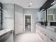 This bathroom features a double vanity with modern fixtures, beautiful tile and an open shower and black soaking tub at 6607 Whispering Pines Rd, Orlando, FL 32824
