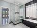 This bathroom features an open shower with modern fixtures, beautiful tile and a black stand alone soaking tub at 6607 Whispering Pines Rd, Orlando, FL 32824