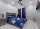 Cozy bedroom featuring a dark blue bedspread, marble floors, and a ceiling fan at 6607 Whispering Pines Rd, Orlando, FL 32824
