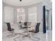 Dining area with glass table, modern chairs, contemporary light fixture and large windows at 6607 Whispering Pines Rd, Orlando, FL 32824