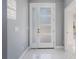 Bright foyer featuring a glass panel front door, gray walls, and white marble floors at 6607 Whispering Pines Rd, Orlando, FL 32824