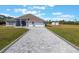 Single-story home featuring a three-car garage, long paved driveway, and spacious front lawn at 6607 Whispering Pines Rd, Orlando, FL 32824