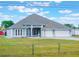 Single-story home featuring a three-car garage, spacious front lawn, and an elegant neutral color palette at 6607 Whispering Pines Rd, Orlando, FL 32824