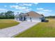 Aerial view of single-story home featuring a three-car garage, paved driveway, and manicured lawn at 6607 Whispering Pines Rd, Orlando, FL 32824