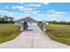 Beautiful single-story home with a well-manicured lawn and a concrete driveway with a gated entrance at 6607 Whispering Pines Rd, Orlando, FL 32824