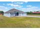 Single-story home featuring a three-car garage, spacious front lawn, and elegant neutral color palette at 6607 Whispering Pines Rd, Orlando, FL 32824