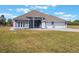 Single-story home featuring a three-car garage, spacious front lawn, and an elegant neutral color palette at 6607 Whispering Pines Rd, Orlando, FL 32824