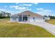 Beautiful single-story home featuring a three-car garage, paved driveway, and well-manicured lawn at 6607 Whispering Pines Rd, Orlando, FL 32824