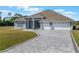 Single-story home featuring a three-car garage, spacious front lawn, and an elegant neutral color palette at 6607 Whispering Pines Rd, Orlando, FL 32824