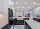 Well-lit kitchen with modern appliances, a farmhouse sink, and stylish two-tone cabinetry at 6607 Whispering Pines Rd, Orlando, FL 32824