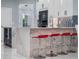 Modern kitchen featuring waterfall island with seating and stainless steel appliances and sleek white cabinetry at 6607 Whispering Pines Rd, Orlando, FL 32824