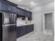 A modern kitchen features stainless steel appliances and stylish dark blue cabinetry and backsplash at 6607 Whispering Pines Rd, Orlando, FL 32824