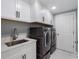 This laundry room has modern washer and dryer and sink at 6607 Whispering Pines Rd, Orlando, FL 32824