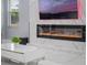 Close up of a fireplace set within an accent wall, illuminated, with large format marble style tile at 6607 Whispering Pines Rd, Orlando, FL 32824