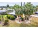 An aerial view of a yellow home nestled among palm trees and well-manicured landscaping at 726 Viking Ave, Tavares, FL 32778