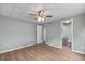 This bedroom has a ceiling fan, wood-look flooring, and an adjacent bathroom for added convenience at 726 Viking Ave, Tavares, FL 32778