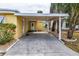 A covered carport featuring lush landscaping, a side entry door, and room for parking at 726 Viking Ave, Tavares, FL 32778