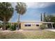 Relaxing home boasting mature palm trees, a carport, and a well-maintained lawn at 726 Viking Ave, Tavares, FL 32778