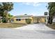 Inviting single-story home with bright yellow exterior and carport, complemented by a well-kept lawn and established landscaping at 726 Viking Ave, Tavares, FL 32778