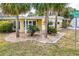 Charming yellow home framed by lush palm trees and beautiful landscaping, creating a tropical oasis at 726 Viking Ave, Tavares, FL 32778