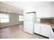 Open kitchen and dining area with white cabinets, new appliances, and laminate flooring at 726 Viking Ave, Tavares, FL 32778