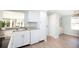 Bright kitchen featuring white cabinets, gray countertops, and laminate flooring at 726 Viking Ave, Tavares, FL 32778