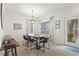 Bright dining area features a wooden table, modern chairs, tile flooring and large windows with elegant window treatments at 8029 Acadia Estates Ct, Kissimmee, FL 34747