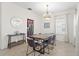 Dining room with a large table, modern chandelier, and tile flooring, adjacent to the kitchen with stainless steel appliances at 8029 Acadia Estates Ct, Kissimmee, FL 34747