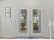 Elegant double front doors with decorative glass inlays, complemented by a stylish rug and neutral wall decor at 8029 Acadia Estates Ct, Kissimmee, FL 34747
