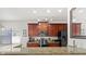 Kitchen with dark wood cabinets, granite countertops, stainless steel appliances, and track lighting above the breakfast bar at 8029 Acadia Estates Ct, Kissimmee, FL 34747