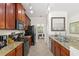 A view of the kitchen with dark cabinetry, granite countertops, and stainless steel appliances at 8029 Acadia Estates Ct, Kissimmee, FL 34747