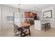 Open-concept kitchen and dining area with dark wood cabinets, granite countertops, and bar seating, perfect for entertaining at 8029 Acadia Estates Ct, Kissimmee, FL 34747