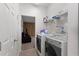 Functional laundry room equipped with a washer, dryer, and ample shelving for storage at 8029 Acadia Estates Ct, Kissimmee, FL 34747