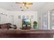 A cozy living room with hardwood flooring, ceiling fan and view to outdoor pool at 8029 Acadia Estates Ct, Kissimmee, FL 34747