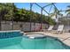 A pool with a jacuzzi and outdoor lounge chairs, surrounded by a fence at 8029 Acadia Estates Ct, Kissimmee, FL 34747
