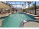 A screened-in pool and jacuzzi with surrounding deck and landscaping at 8029 Acadia Estates Ct, Kissimmee, FL 34747
